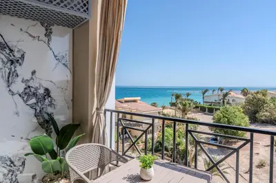 a balcony with a table and chairs and the ocean at Strandapartment mit Meerblick & Pool im Juliana Beach Resort, Hurghada in Hurghada