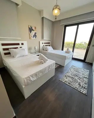 a bedroom with two beds and a large window at Luxury villa in gouna in El Gouna