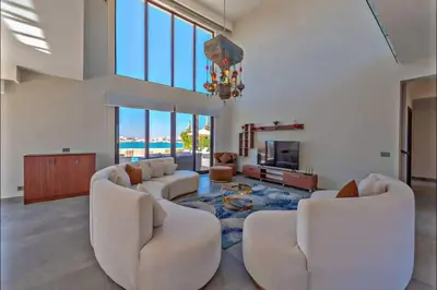 a living room with white furniture and a chandelier at Luxury villa in gouna in El Gouna