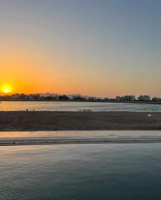 a sunset over a body of water with a beach at Luxury villa in gouna in El Gouna