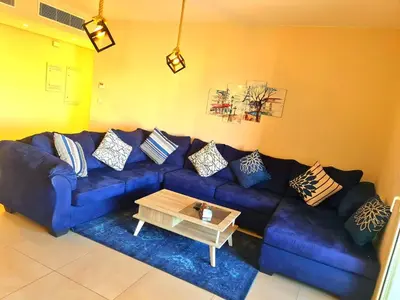 a blue couch in a living room with a coffee table at Mangrove Elgouna in Hurghada