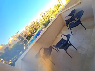 two chairs on a balcony with a view of a resort at Mangrove Elgouna in Hurghada