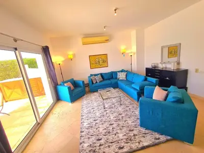 a living room with a blue couch and a rug at White villa in Hurghada