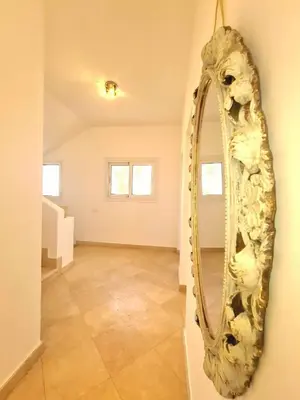 a mirror hanging on a wall in a room at White villa in Hurghada