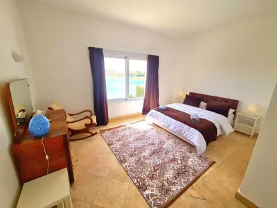 a bedroom with a bed and a large window at White villa in Hurghada