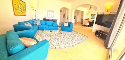 a living room with a blue couch and a television at White villa in Hurghada
