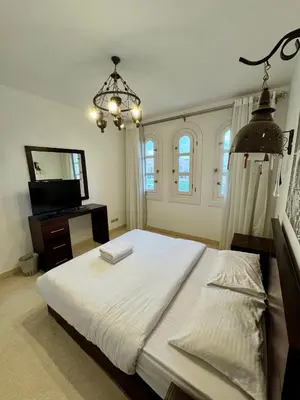 a bedroom with a large white bed and a chandelier at G20-1-5 El golf in Hurghada