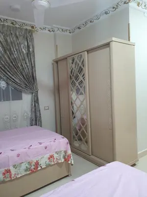 a bedroom with a bed and a cabinet with wine glasses at Queen Feryal in Jazīrat Aswān