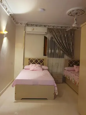 a bedroom with a bed with pink sheets and curtains at Queen Feryal in Jazīrat Aswān