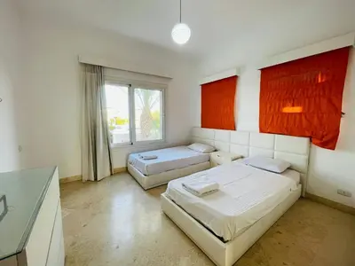 a bedroom with two beds and a window at 5 bedroom villa with private pool at el gouna in Hurghada