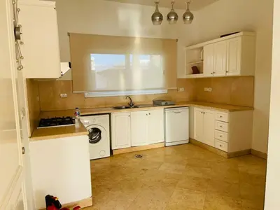 a kitchen with white cabinets and a washer and dryer at 5 bedroom villa with private pool at el gouna in Hurghada