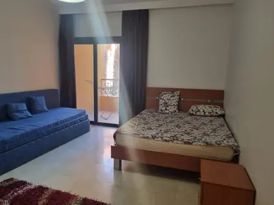 a bedroom with a bed and a blue couch at Esplanadа Apartments in Hurghada