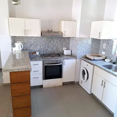 a kitchen with white cabinets and a washer and dryer at 2 Bedrooms First floor in Waterside Residence in Hurghada