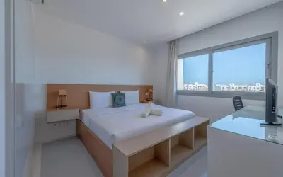 a bedroom with a bed and a large window at Relax in Style I Lagoon-Front 2BR in Swan Lake El Gouna in Hurghada
