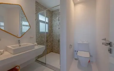 a bathroom with a sink and a toilet and a mirror at Relax in Style I Lagoon-Front 2BR in Swan Lake El Gouna in Hurghada