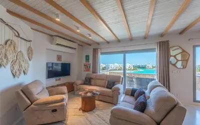 a living room with two couches and a tv at Relax in Style I Lagoon-Front 2BR in Swan Lake El Gouna in Hurghada