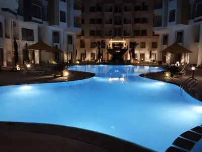 a large swimming pool lit up at night at Studiowohnung Aqua Infinity in Hurghada