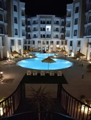a large pool in front of a building at night at Studiowohnung Aqua Infinity in Hurghada