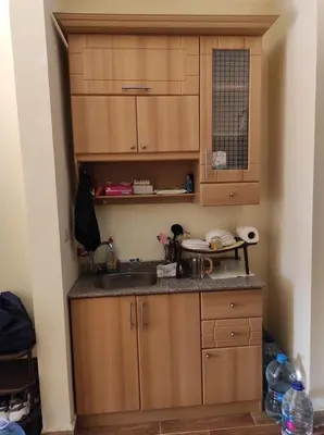 a kitchen with wooden cabinets and a sink at Florenza Khamsin Resort compound in Hurghada