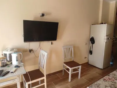 a room with a refrigerator and a table and chairs at Florenza Khamsin Resort compound in Hurghada