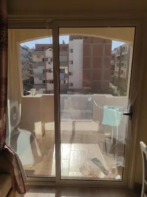 a sliding glass door with a view of a balcony at Florenza Khamsin Resort compound in Hurghada