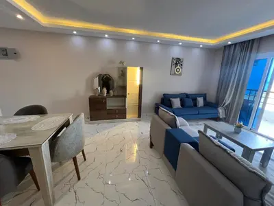 a living room with a blue couch and a table at Hurghada Fanadir Bay in Hurghada
