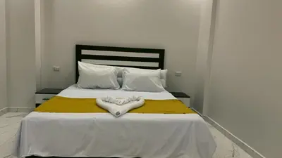 a bedroom with a bed with white sheets and white pillows at Prestige Residency in Hurghada