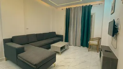 a living room with a couch and a tv at Prestige Residency in Hurghada