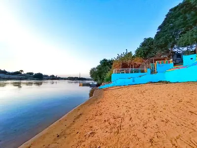a blue fence on a beach next to the water at Fox Nubian Hotel in Aswan