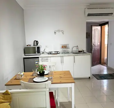 a kitchen with a wooden table with chairs and a tableasteryasteryasteryasteryastery at Studio By The Beach in Hurghada