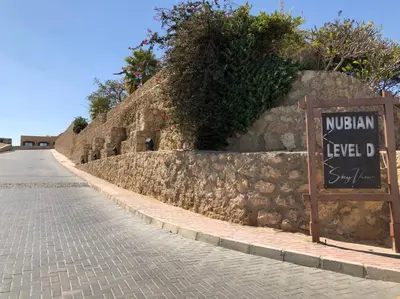 a stone wall with a sign on the side of a street at Studio By The Beach in Hurghada