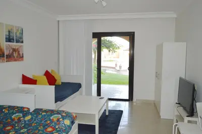 a living room with a couch and a tv at Studio By The Beach in Hurghada