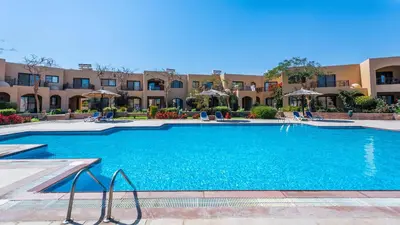 a large swimming pool in front of a building at Studio By The Beach in Hurghada