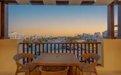 a table and chairs on a balcony with a view at Relaxing 3BR Fanadir Marina Home l El Gouna Red Sea l Lagoon Views in Hurghada