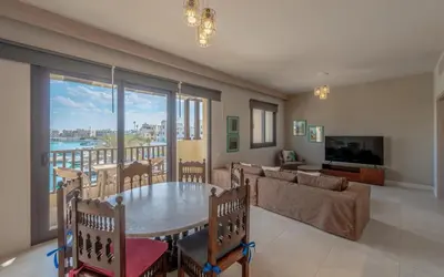 a living room with a table and a couch at Relaxing 3BR Fanadir Marina Home l El Gouna Red Sea l Lagoon Views in Hurghada