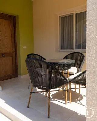 a patio with three chairs and a table and a window at Stylish flat with terrace in Hurghada