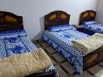 a room with two beds and a chair in it at Makky ka in Jazīrat Suhayl