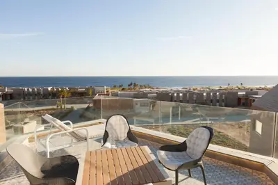 a balcony with a table and chairs and the ocean at Stylish Seaview 2BR Soma bay Villa with Free Pool & Beach in Hurghada