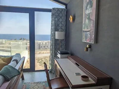 a living room with a desk and a large window at Stylish Seaview 2BR Soma bay Villa with Free Pool & Beach in Hurghada
