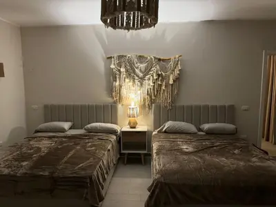 a bedroom with two beds and a chandelier at 2 BR with a small private pool in Hurghada