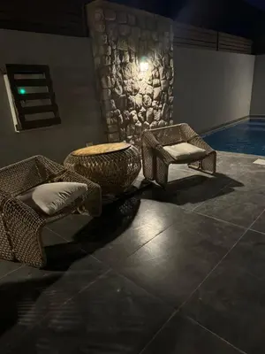 a room with two chairs and a table and a pool at 2 BR with a small private pool in Hurghada