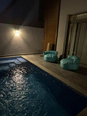 a swimming pool at night with two pillows next to it at 2 BR with a small private pool in Hurghada