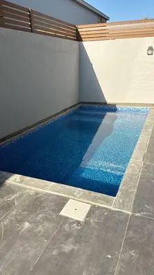a swimming pool with blue water in a building at 2 BR with a small private pool in Hurghada