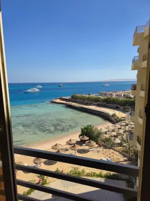 a view of the beach from the balcony of a resort at Dive Hostel Hurghada Beach in Hurghada