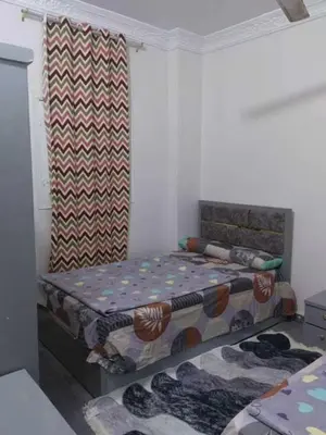 a small bedroom with two beds and a curtain at شقة فاخرة خلف الاستاد اسوان in Aswan