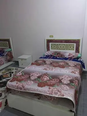 a bedroom with a bed with a floral bedspread at شقة فاخرة خلف الاستاد اسوان in Aswan