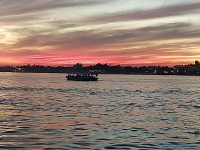 a small boat on the water at sunset at Luxor Experience Guest House in Luxor