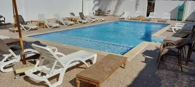 a swimming pool with chairs and a bunch of chairs at Luxor Experience Guest House in Luxor