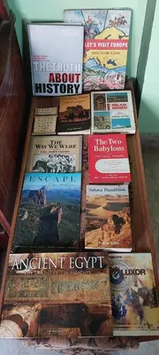 a pile of books sitting on top of a table at Luxor Experience Guest House in Luxor
