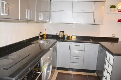 a white kitchen with a sink and a dishwasher at GoEgypt Dreams in Hurghada